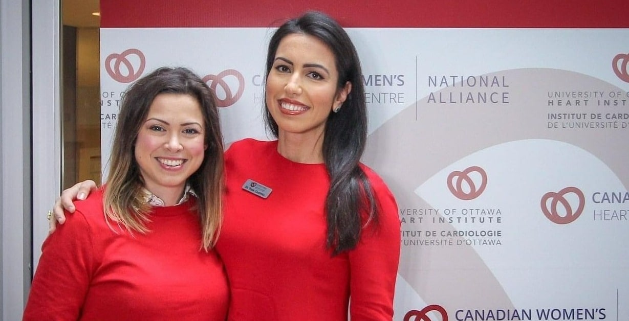 Two women in red outfits smiling.