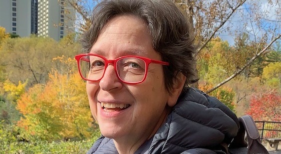 Person outdoors with autumn foliage.