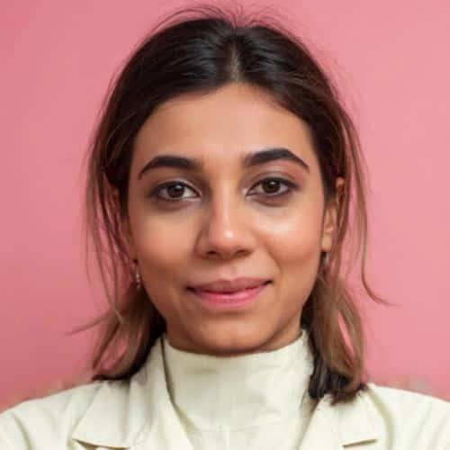 Person with pink background, neutral expression.