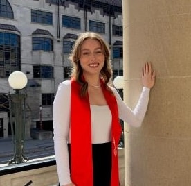Person in red scarf by column