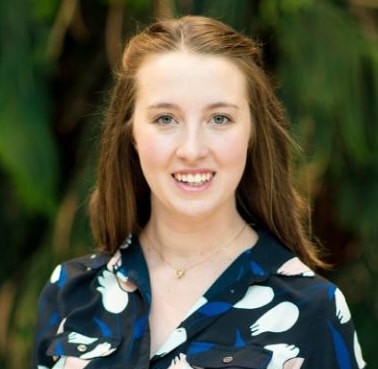 Woman in patterned shirt outdoors.
