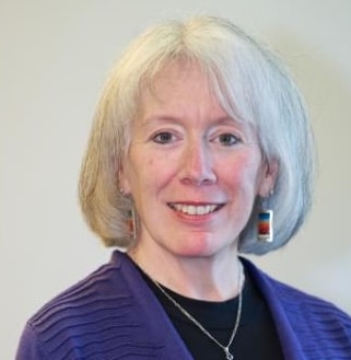 Woman with gray hair and earrings.