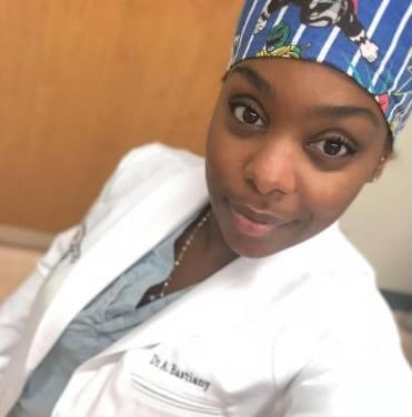 Person in medical attire and headscarf.