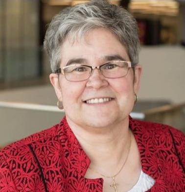 Woman in red jacket, neutral background.