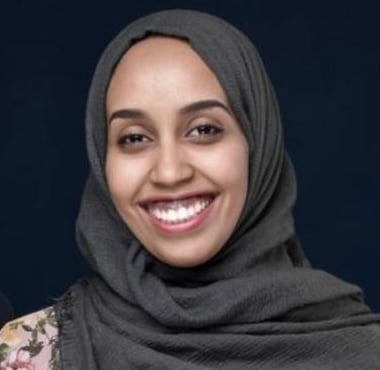 Person wearing a dark headscarf.