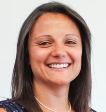 Person with dark hair and necklace