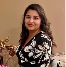 Woman in floral dress posing elegantly.