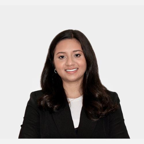 Person in black blazer, arms crossed.