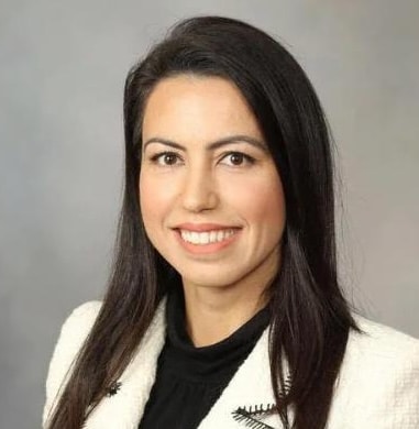 Person in formal attire, neutral background.